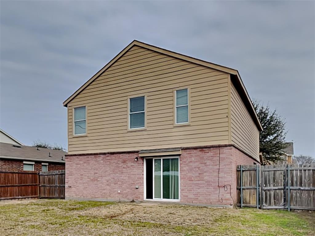 216 Turning Tree Road Wilmer, TX 75172 - Photo 18 of 20 Back of house with a fenced backyard, brick siding, and a gate