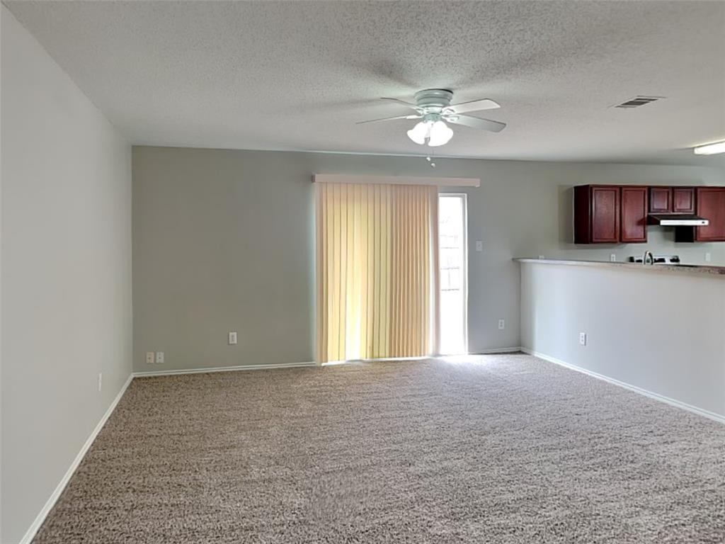 216 Turning Tree Road Wilmer, TX 75172 - Photo 2 of 20 Unfurnished living room with carpet flooring, ceiling fan, and a textured ceiling