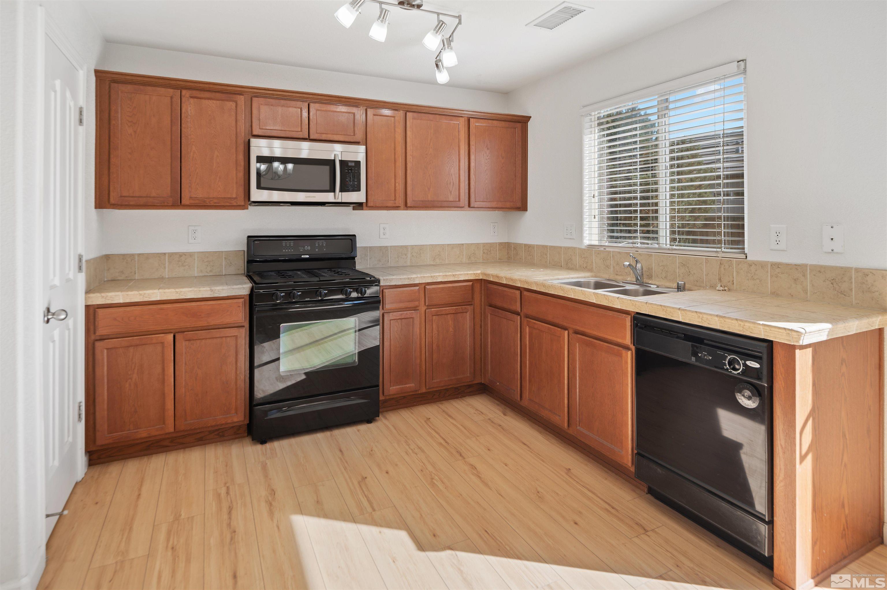 11360 Verazae Drive Reno, NV 89521 - Photo 6 of 22 a kitchen with a sink stove and microwave