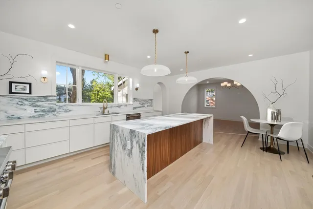 a kitchen with stainless steel appliances granite countertop a stove a sink and a refrigerator