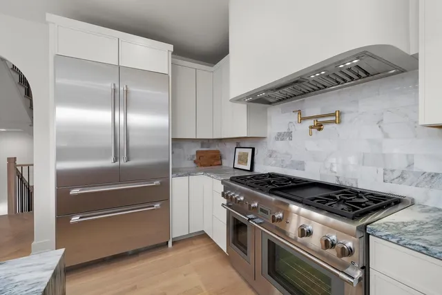 a view of a room with a chandelier and wooden floor