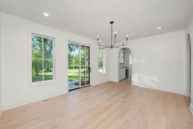 a living room with furniture and a dining table with wooden floor