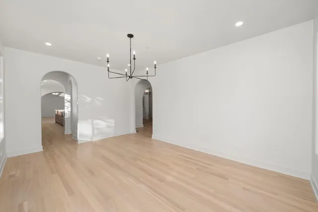 a large kitchen with stainless steel appliances granite countertop a stove and a wooden floors