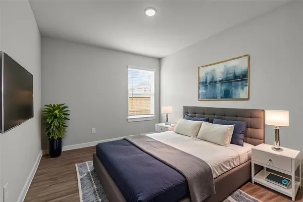 a bedroom with bed and a potted plant