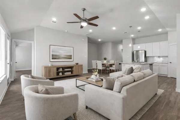a living room with furniture kitchen view and a window