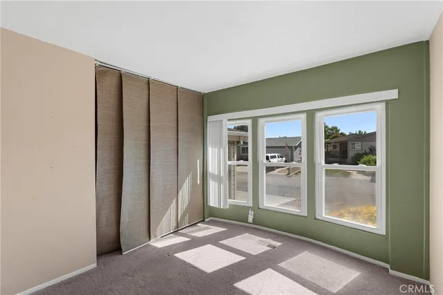 a view of an empty room with glass door and a window