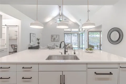 a kitchen with cabinets a window and a chandelier