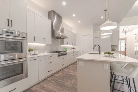 a kitchen with granite countertop a sink stainless steel appliances and cabinets
