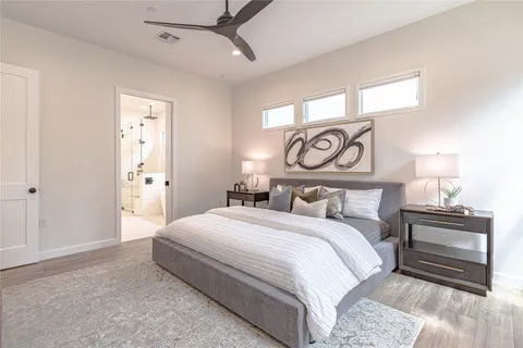 a bedroom with a bed and a lamp on a dresser