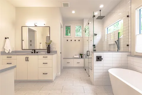 a bathroom with a granite countertop sink mirror and bathtub