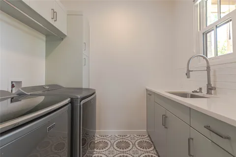 a utility room with sink dryer and washer