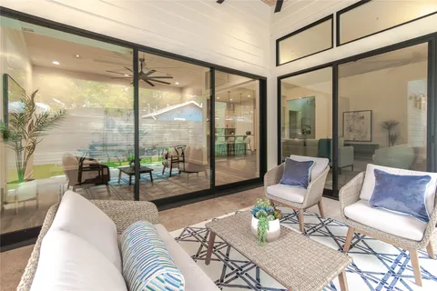 a living room with furniture and floor to ceiling windows