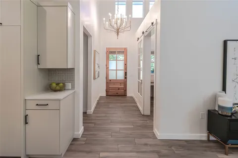 a view of a hallway with wooden floor and staircase