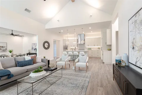 a living room with lots of furniture and view of kitchen