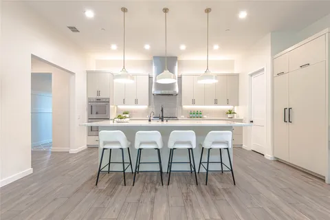 a dining room with stainless steel appliances kitchen island a chandelier