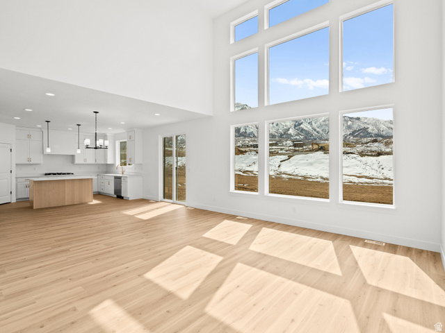 1524 West 1400 North, Unit 2 Mapleton, UT 84664 - Photo 2 of 8 Two-story living area with expansive window walls, light wood-finish flooring, and white walls
