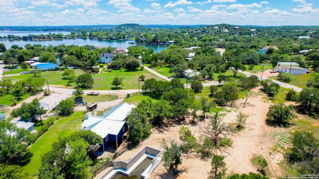 an aerial view of residential houses with outdoor space and trees