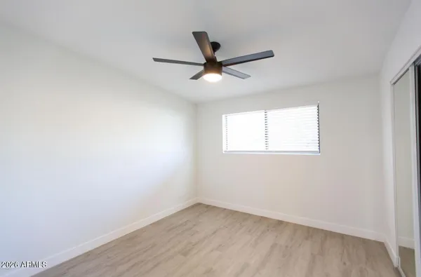 an empty room with a window and a fan