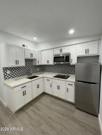 a kitchen with granite countertop white cabinets and white appliances