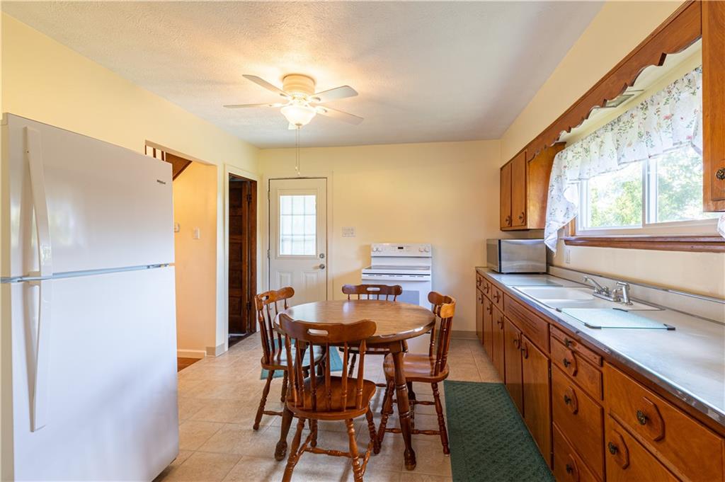 216 Carson Road Dawson, PA 15428 - Photo 8 of 25 a kitchen with a table chairs refrigerator and window
