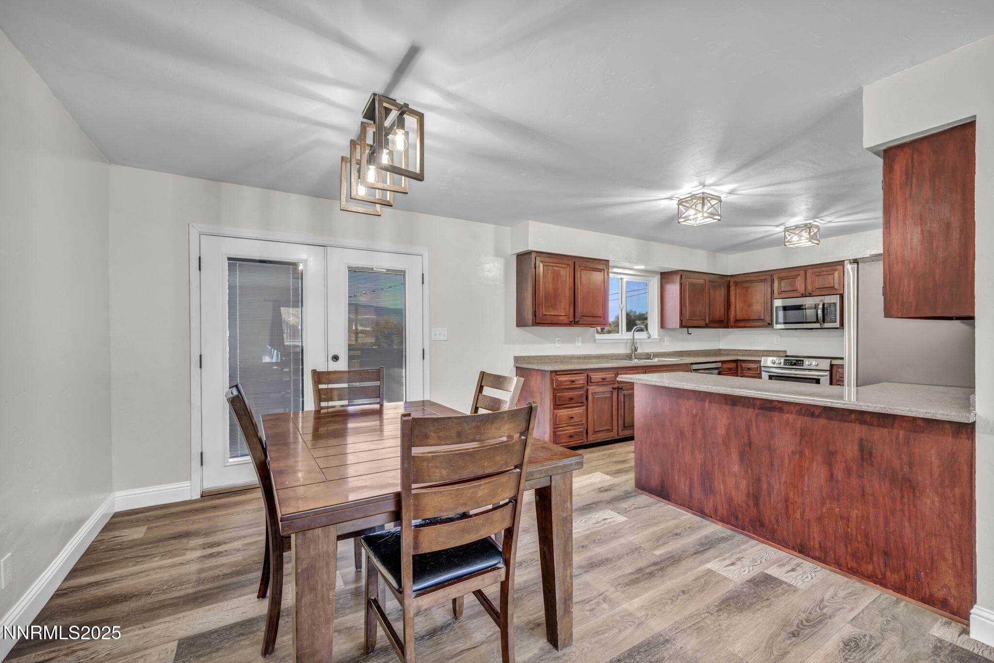 14595 Chamy Drive Reno, NV 89521 - Photo 19 of 66 a dining room with wooden floor a chandelier a wooden table and chairs