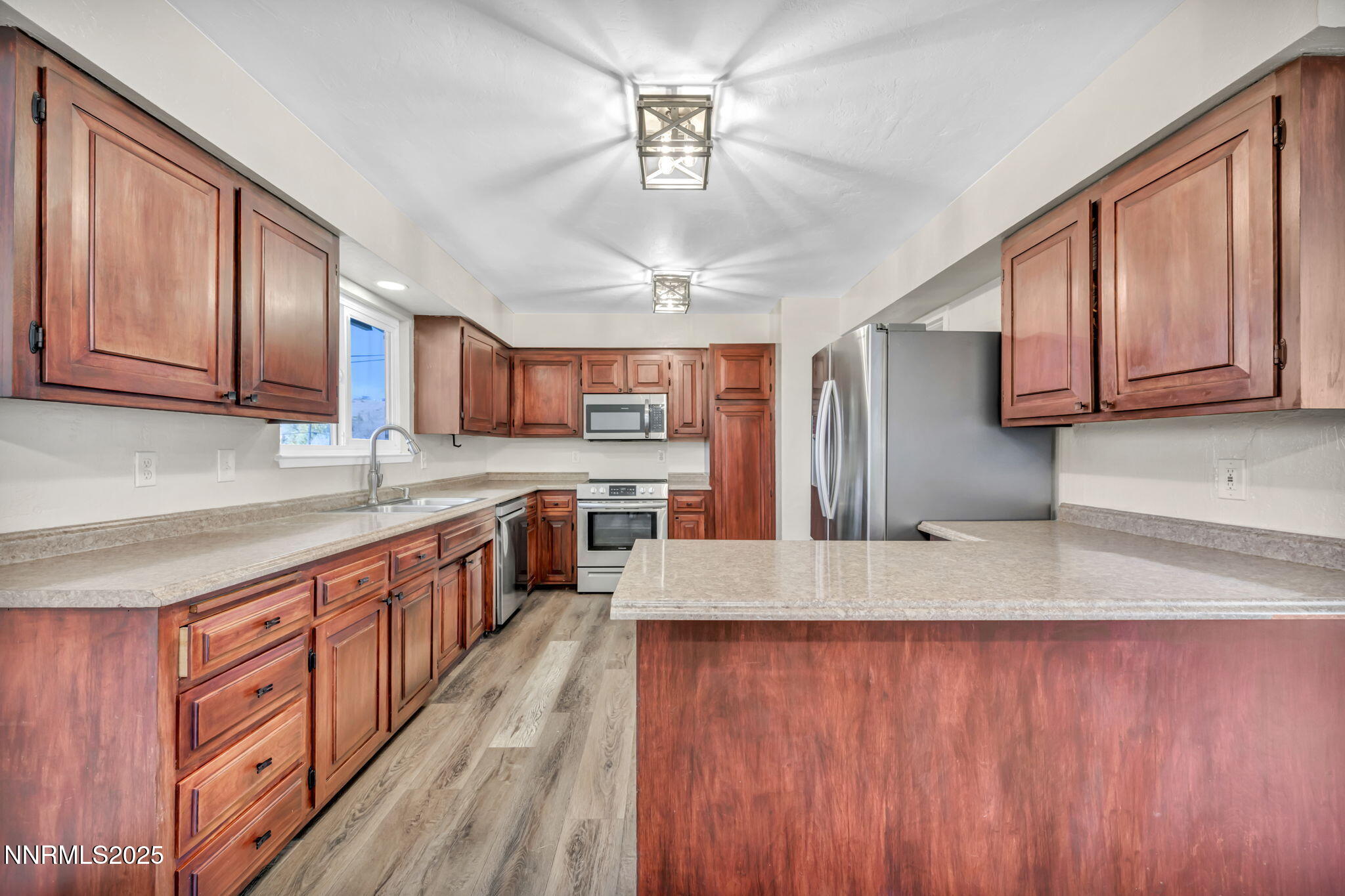 14595 Chamy Drive Reno, NV 89521 - Photo 24 of 66 a large kitchen with stainless steel appliances granite countertop a stove a sink dishwasher and a refrigerator with wooden floor