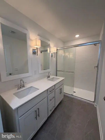 a bathroom with a double vanity sink and mirror with shower