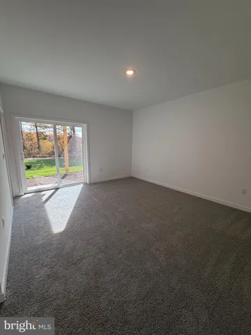 an empty room with floor to ceiling windows and a ceiling fan