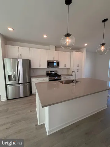 a kitchen with stainless steel appliances granite countertop a refrigerator a stove a sink dishwasher a oven with a dining table and chairs