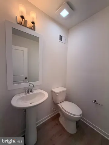a bathroom with a toilet a sink and mirror