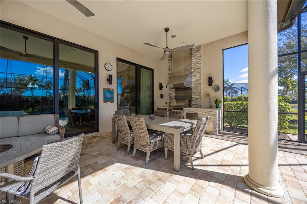6502 Roma Way Naples, FL 34113 - Photo 12 of 43 a dining room with furniture a chandelier and glass door