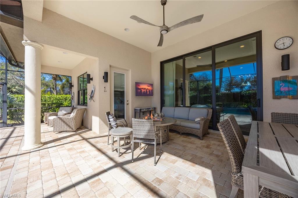 6502 Roma Way Naples, FL 34113 - Photo 13 of 43 a living room with patio furniture and a floor to ceiling window