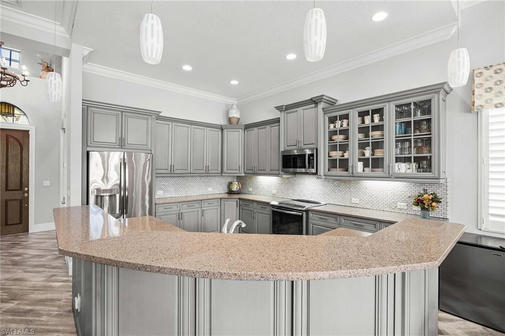 6502 Roma Way Naples, FL 34113 - Photo 15 of 43 a kitchen with stainless steel appliances granite countertop a sink counter space and cabinets