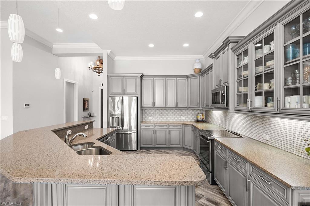 6502 Roma Way Naples, FL 34113 - Photo 16 of 43 a kitchen with a sink a stove and cabinets
