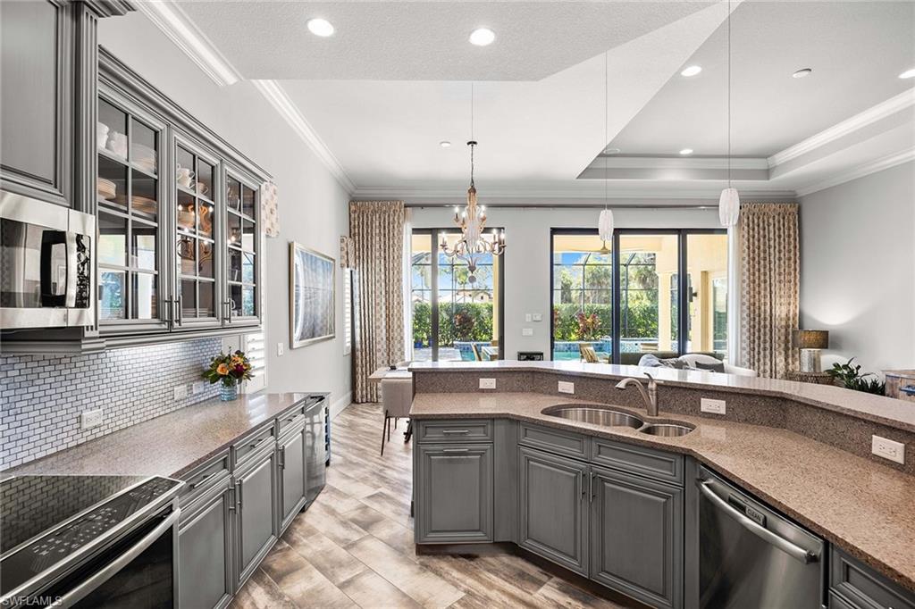 6502 Roma Way Naples, FL 34113 - Photo 17 of 43 a large kitchen with stainless steel appliances a sink and cabinets
