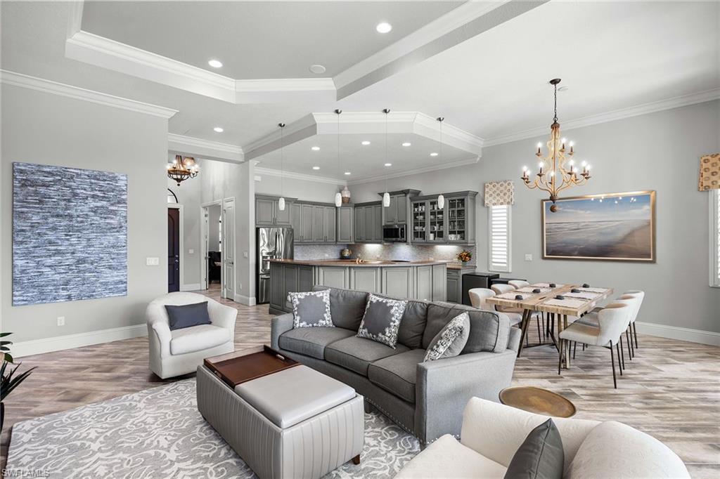 6502 Roma Way Naples, FL 34113 - Photo 22 of 43 a living room with furniture kitchen view and a chandelier