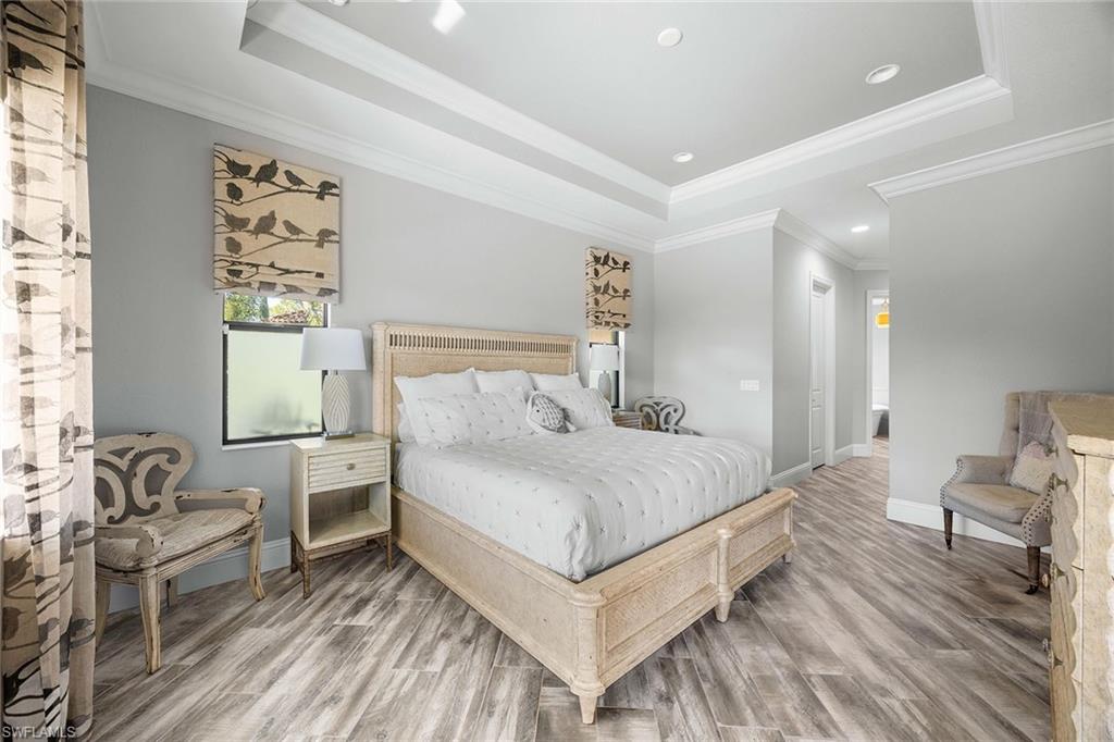 6502 Roma Way Naples, FL 34113 - Photo 24 of 43 a bedroom with a bed and chair