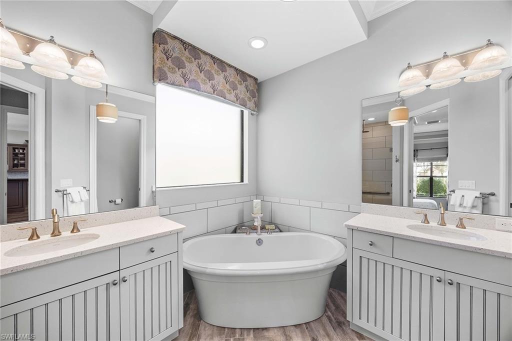 6502 Roma Way Naples, FL 34113 - Photo 25 of 43 a bathroom with a double vanity sink mirror and a bathtub