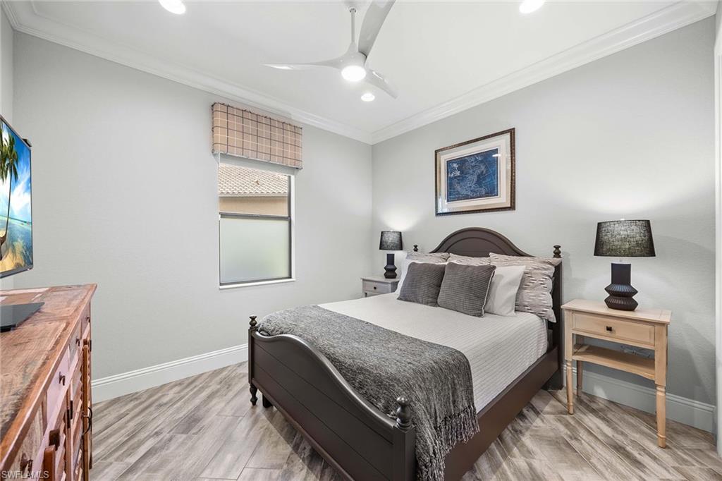 6502 Roma Way Naples, FL 34113 - Photo 27 of 43 a bedroom with a bed and a night stand