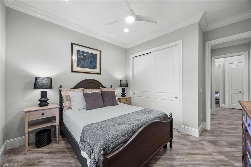 6502 Roma Way Naples, FL 34113 - Photo 28 of 43 a bedroom with a bed and a lamp