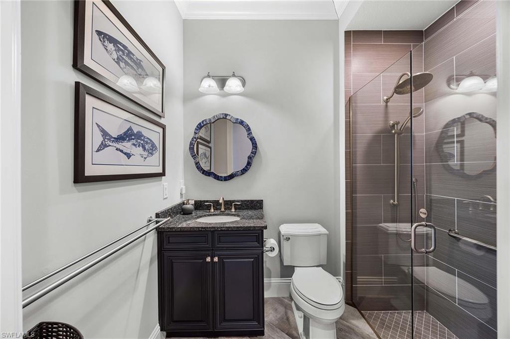 6502 Roma Way Naples, FL 34113 - Photo 31 of 43 a bathroom with a toilet a sink and a mirror