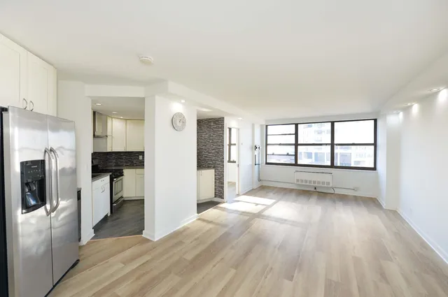 a view of a kitchen with a sink refrigerator and wooden floor