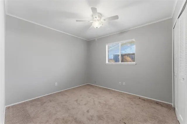 an empty room with a window and a ceiling fan