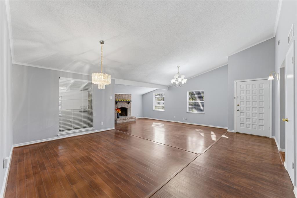1805 Haymeadow Carrollton, TX 75007 - Photo 2 of 20 an empty room with wooden floor chandelier and windows