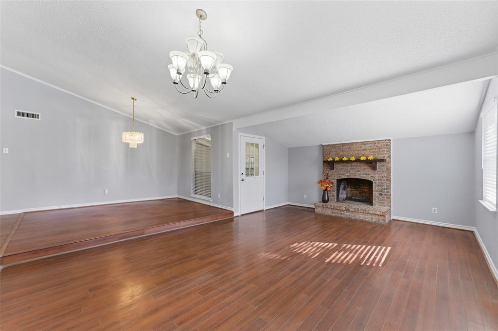 1805 Haymeadow Carrollton, TX 75007 - Photo 3 of 20 a view of an empty room with wooden floor fireplace and a window