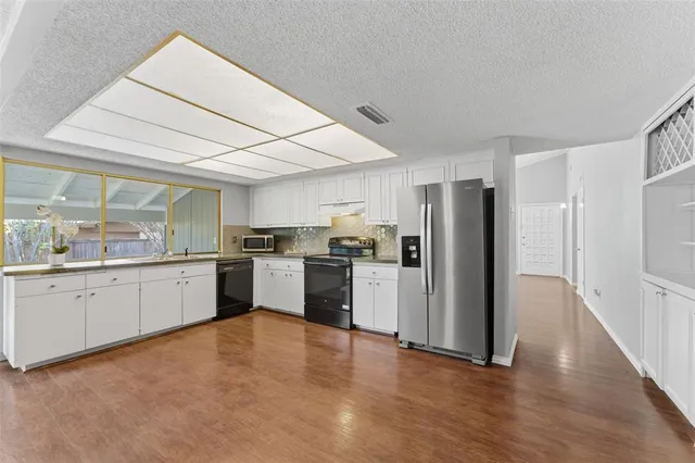 a kitchen with white cabinets and stainless steel appliances