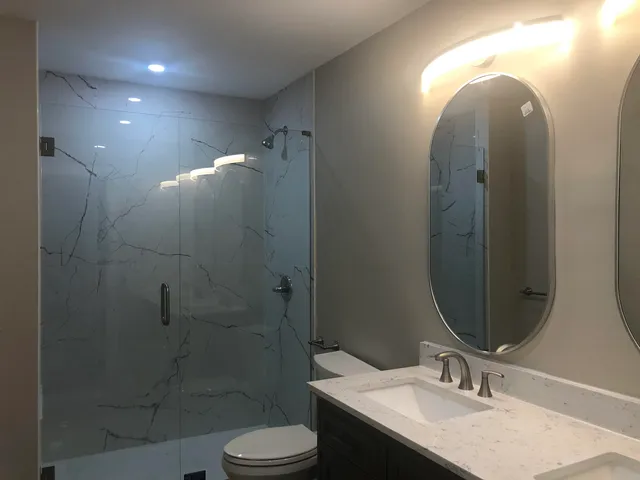 a bathroom with a sink a toilet and shower