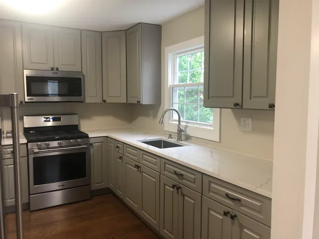 a kitchen with stainless steel appliances granite countertop a sink stove and microwave