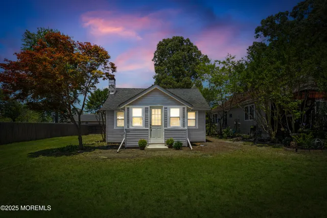 a view of a yard in front of a house with a large tree