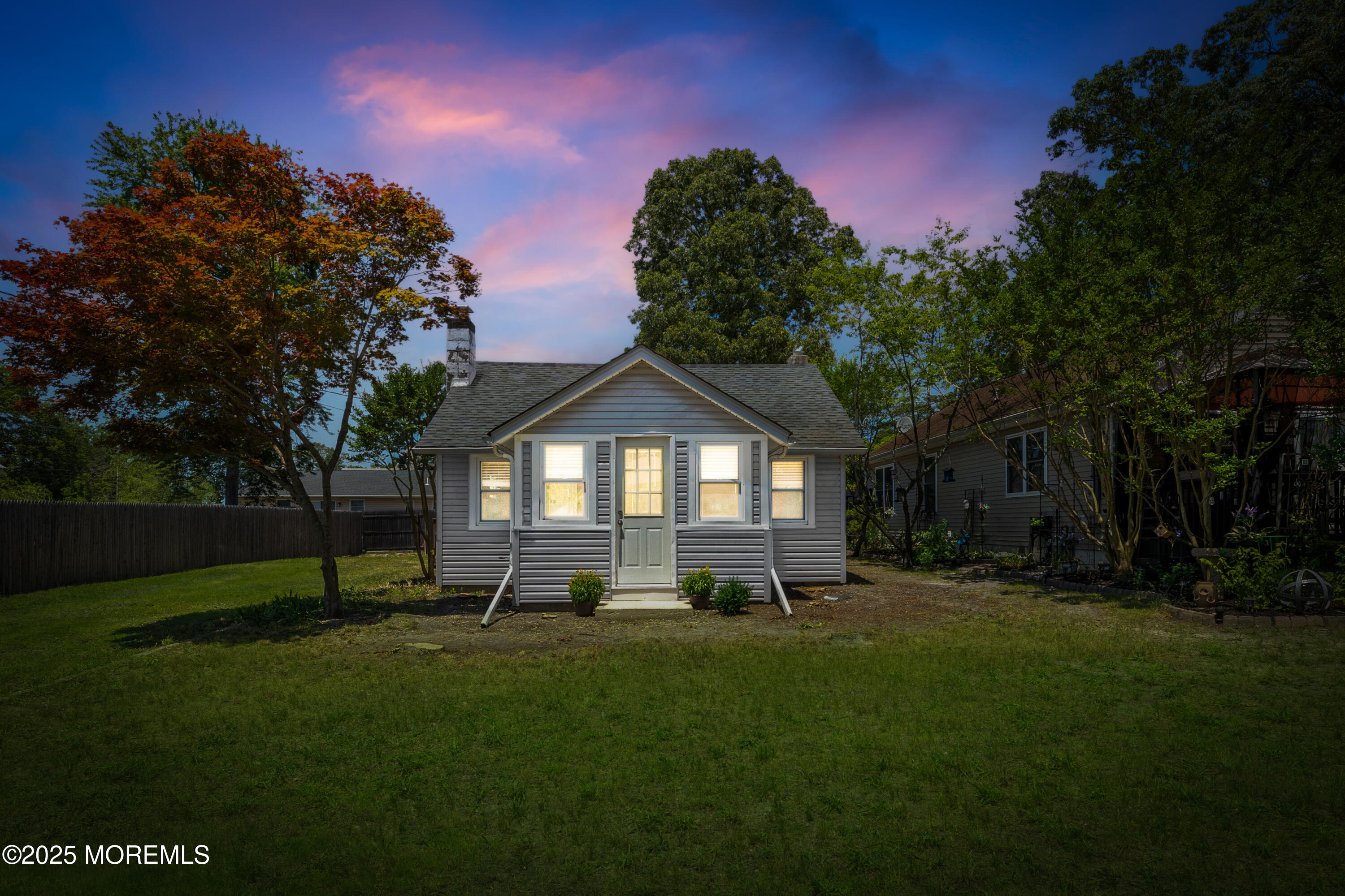 a view of a yard in front of a house with a large tree